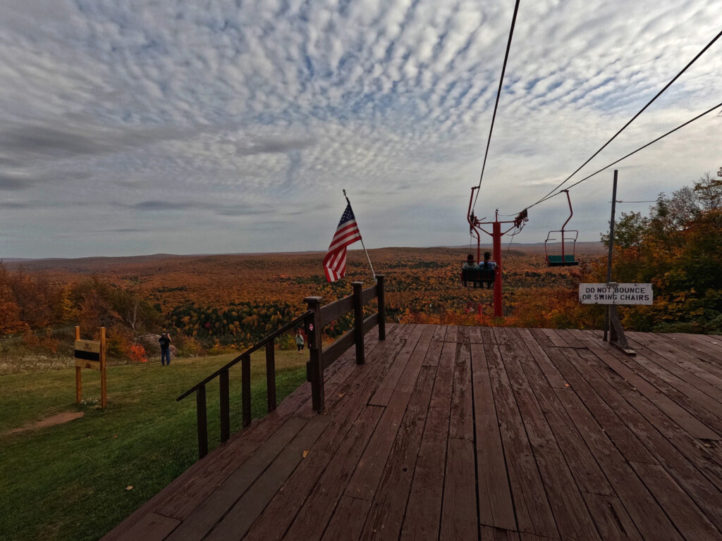 A couple begins their descent from the top of COpper Peak on the chair lift during fall.