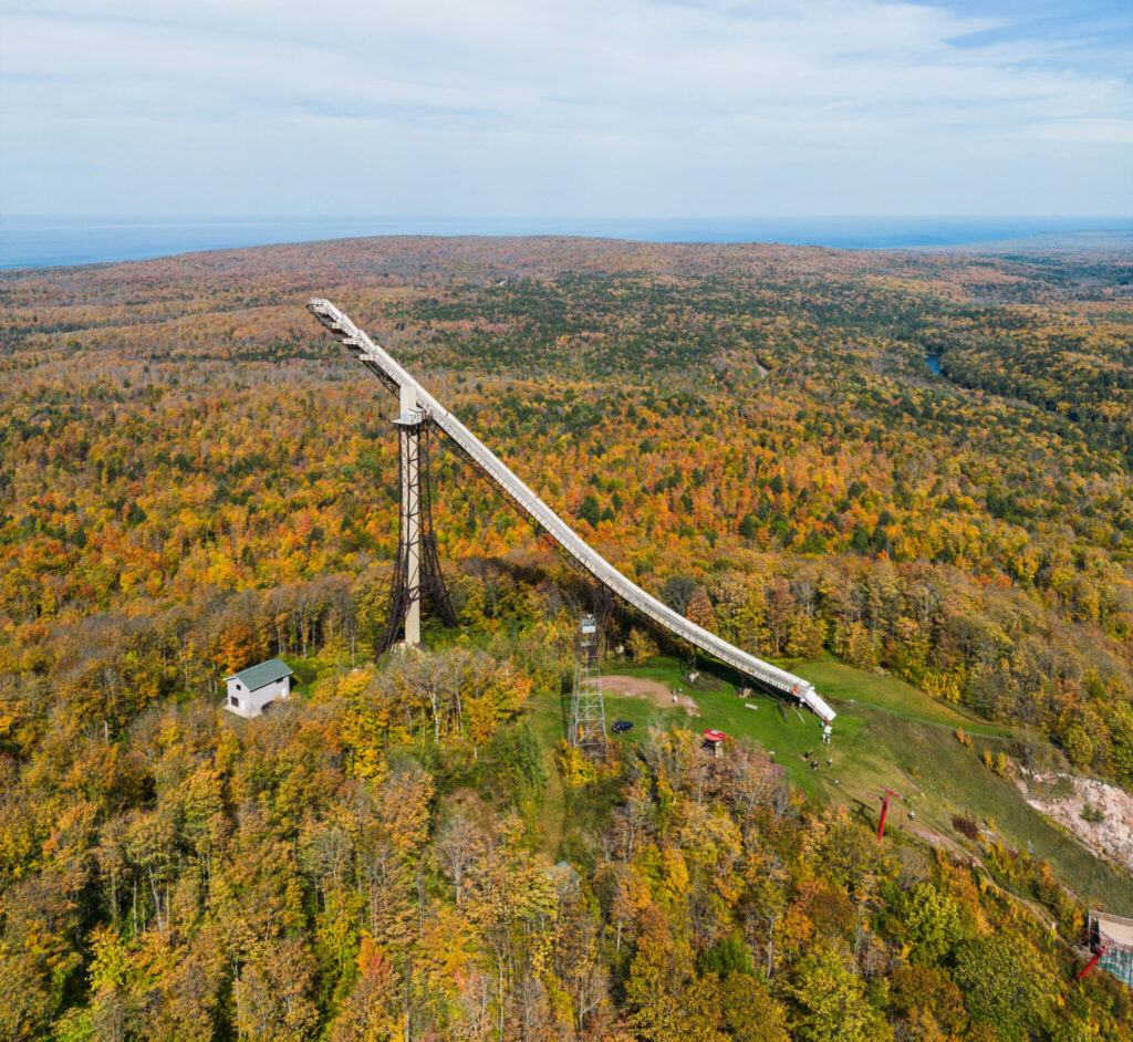 An aerial view of the Copper Peak ski jump adventure ride, surrounded by dense Michigan forest